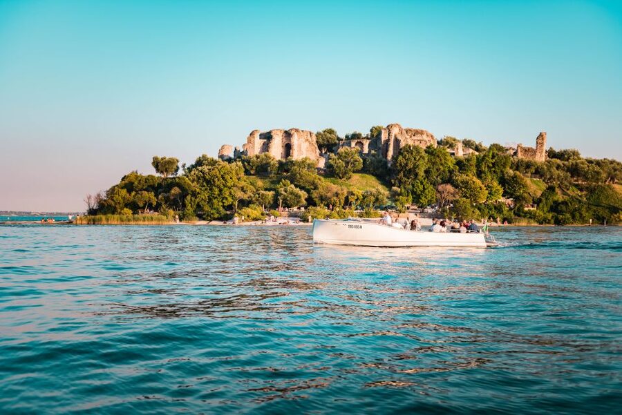 Desenzano del Garda: Sunset Boat Trip at Sunset with Drink - The first view of Sirmione from the lake